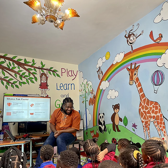 Bernard reading Esi the Brave with children seated around him