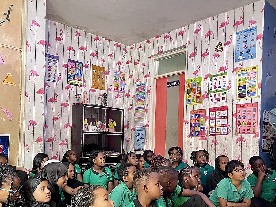 Children and adults listening at a classroom reading
